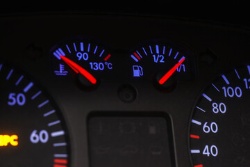 Car dashboard with fuel and engine temperature gauges, closeup