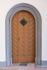 Vintage wooden doorway with charm, oldfashioned wooden archway set against textured white wall