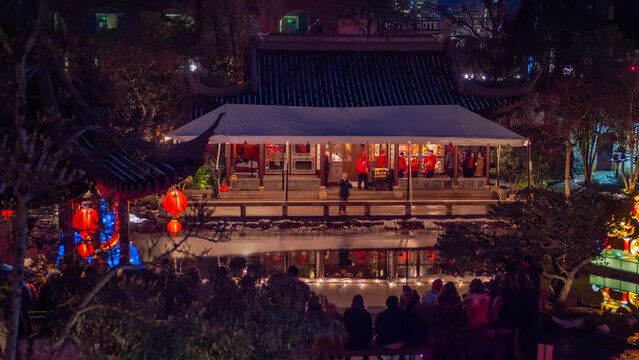 Portland, United States - 15 February 2025: View of the Lan Su Chinese Garden, illuminated by soft lights reflecting on the water, creating a mesmerizing scene.