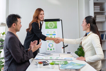 Business partners making an agreement and shaking hands in an office, discussing sustainability and corporate social responsibility
