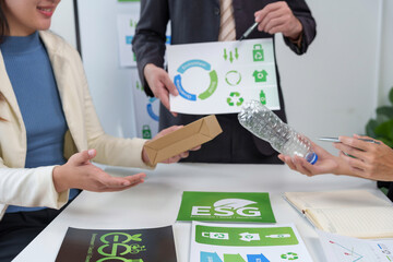 Business professionals analyzing different packaging materials like plastic bottles and cardboard boxes during an ESG and recycling discussion