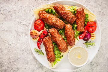 Arabic Cuisine; Grilled Kofta Kebab is one of the most popular dishes in Egypt and entire Mediterranean region. Served on Arabic flat bread, fresh chopped parsley and grilled veggies with tahini sauce