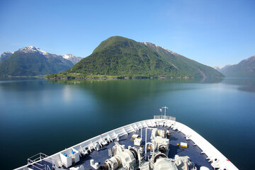 Bow or front of a ship as it cruises down the Sognefjord or Sognefjorden,  Vestland county in Western Norway. Beautiful landscape with reflections in the fjord of the mountains.