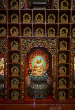 View of golden Buddha statues enshrined within ornately carved wooden niches, radiating tranquility and spiritual depth, Kuala Lumpur, Federal Territory of Kuala Lumpur, Malaysia.