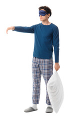 Young male sleepwalker with sleeping mask and pillow isolated on white background