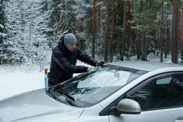 A man is wiping his car window with a cloth. Keeping the car clean. Cleaning maintenance of the car.