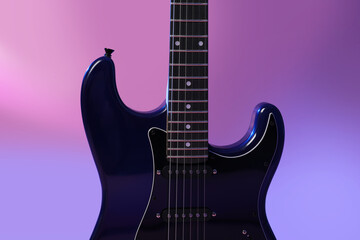 Fototapeta premium Modern electric guitar on purple background, closeup
