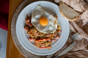 Homemade recipe for white sausage with fried egg on a dining table