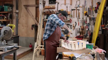 A carpenter assembles an Adirondack chair