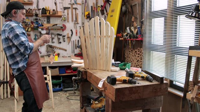 A carpenter assembles an Adirondack chair