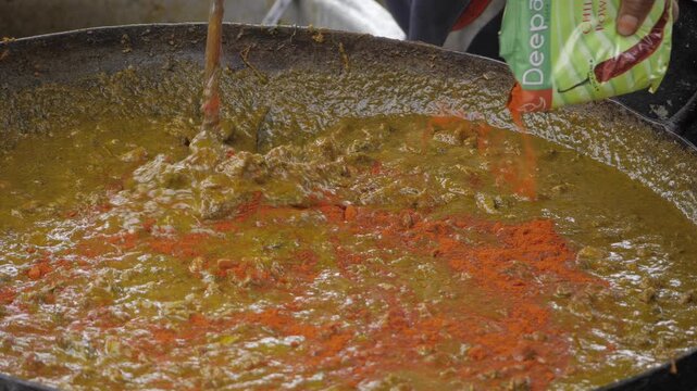 Expert Hand Stirring Deepak Masala into Stunning Curry