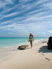 Woman Walking on a White Sand Beach
