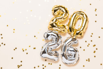 New year 2026 celebration card. Gold and silver foil helium balloons number 2026, party decoration on beige background. Flat lay, copy space, merry christmas banner, happy holidays concept.