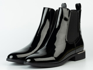 Stylish black boots placed on a plain surface for a clear view