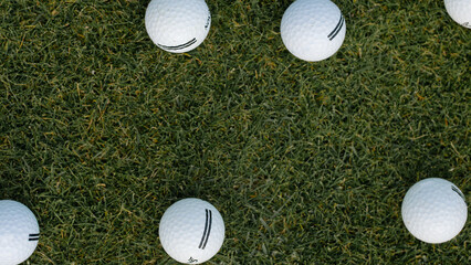 Multiple golf balls on green turf background.