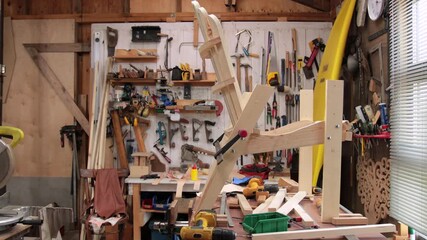 A carpenter assembles an Adirondack chair