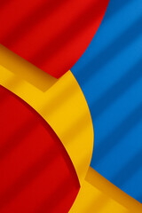 Abstract arrangement of overlapping colored paper in red, yellow, and blue hues. Curved shapes create a dynamic composition with intersecting lines.