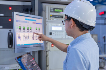 Electrical engineer male checking voltage at the Power Distribution Cabinet in the control room,preventive maintenance Yearly,inspecting power system and control panel in industrial factory