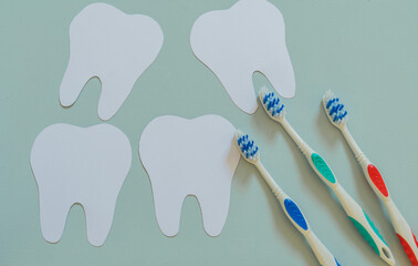 Colorful toothbrushes next to teeth, top view, design for dentist's day greeting card
