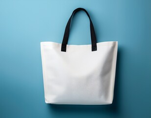 white tote bag with black handles on light blue background