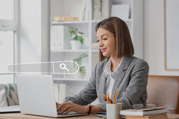Young businesswoman using laptop in office. Concept of search