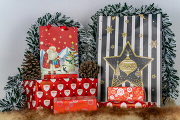 an image of Christmas gifts surrounded by tinsel and pinecones for the festive season 