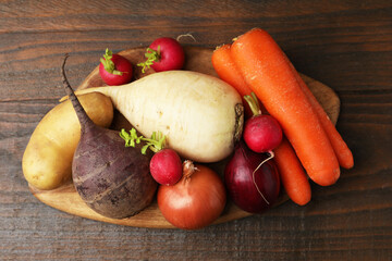 Different raw vegetables on wooden table, top view