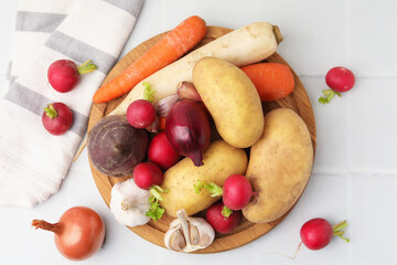 Different raw vegetables on white tiled table, flat lay