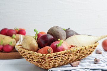 Different raw vegetables on white tiled table, closeup