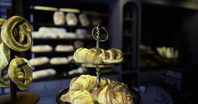 Delicious pastries are artfully arranged on a tiered stand, illuminated softly in a charming bakery that creates a warm and inviting atmosphere during the evening hours.