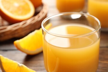 Fresh orange juice and fruits on wooden table, closeup