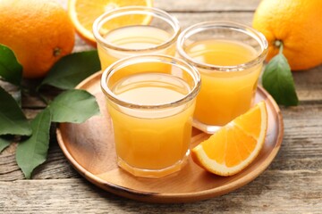 Fresh orange juice and fruits on wooden table, closeup