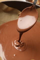 Taking liquid chocolate dough with spoon from baking dish, closeup