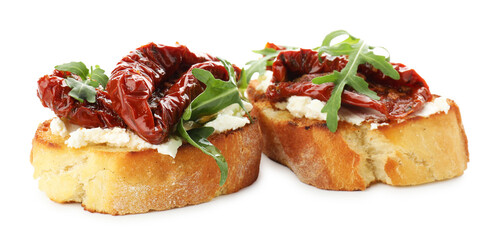 Delicious bruschettas with cream cheese, sun-dried tomatoes and arugula isolated on white