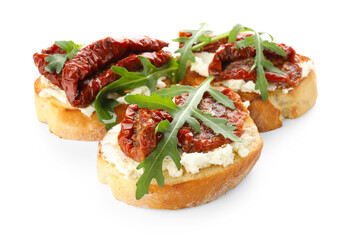 Delicious bruschettas with cream cheese, sun-dried tomatoes and arugula isolated on white