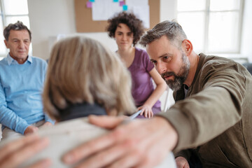 Sharing painful experiences during guided therapeutic session. Empathetic shoulder touch.