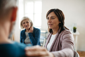 Sharing painful experiences during guided therapeutic session. Empathetic shoulder touch.