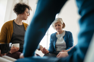Group of people sitting in a circle and sharing experiences during guided therapeutic session.