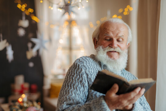 Old man reading from bible during Christmas.