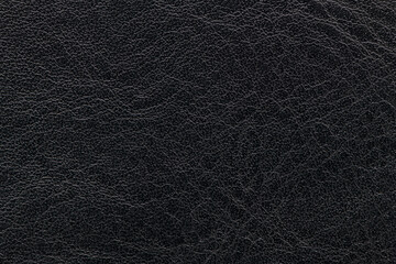 Horizontal macro close-up showcasing the detailed, slightly rough grain and deep charcoal black finish of the leather surface