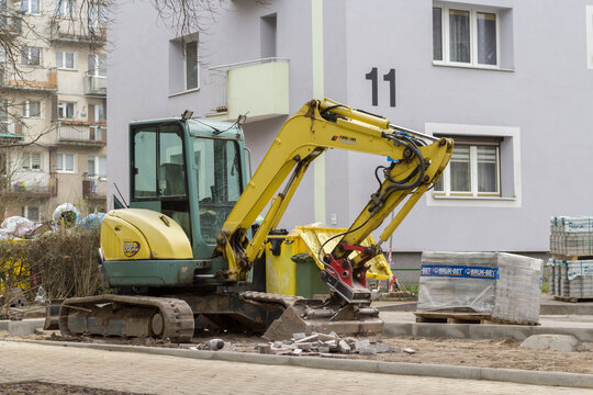 Kielce, Polska. 15.12.2025 - Minikoparka na placu budowy przy bloku mieszkalnym &ndash; roboty ziemne i modernizacja infrastruktury na osiedlu.