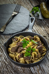 Italian pasta shells with beef sauce in cast iron pan.
