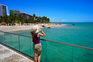 Fototapeta premium Holidays in Brazil. Back view of young woman enjoying viewpoint on belvedere in Maceio, Alagoas, Brazil.