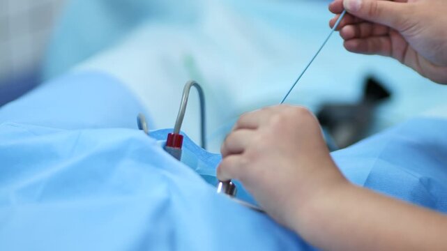 Surgeon performing medical procedure with catheter in operating room during surgery