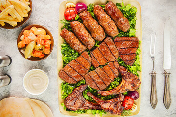 Arabic Cuisine; Assorted mix grills with beef kebab, lamb chops and kofta kebab. Served with pita bread, tahini sauce, pickles and fries.