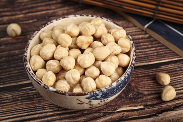 Roasted Macadamia Nuts in Ceramic Bowl on Wood Table
