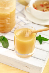 Golden Honey in Glass with Wooden Dipper and Fresh Mint