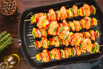 Arabic cuisine; Traditional grilled chicken Shish Kebabs or Shish Tawook on skewers. Top view with close up.