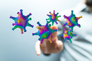 Abstract conceptual image of colourful viruses near human finger, symbolizing digital security or health conce