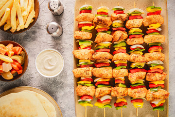 Arabic cuisine; Traditional grilled chicken Shish Kebabs or Shish Tawook on skewers. Top view with close up.